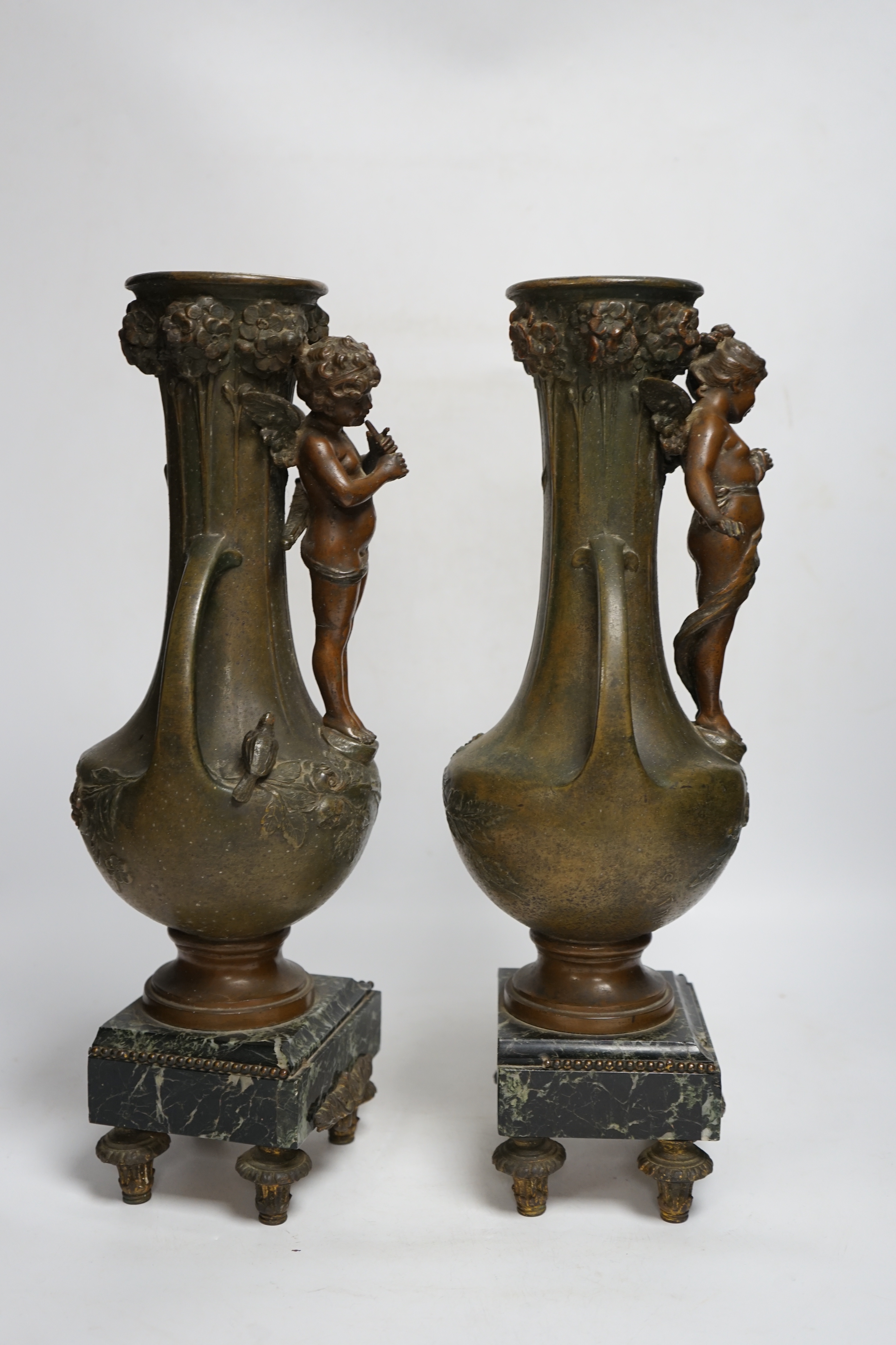 After Hippolyte François-Moreau (1832-1927), a pair of bronzed spelter cherubic vases on marble bases, 42cm